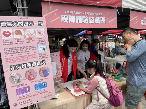 導盲犬志工協助活動攤棚的視障體驗小遊戲